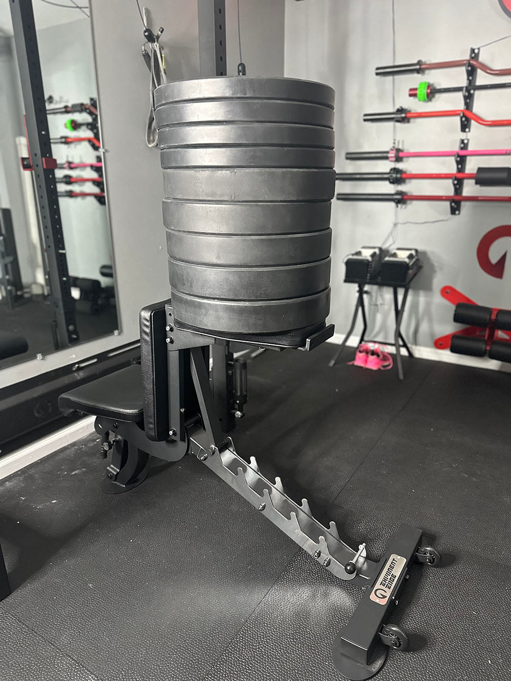 The Edge Infinity Bench is a bench that combines three separate benches all into one bench. You get the benefits of a flat bench, incline bench, and half bench all in one device. This image presents a close-up of the bench supporting several weight plates. 