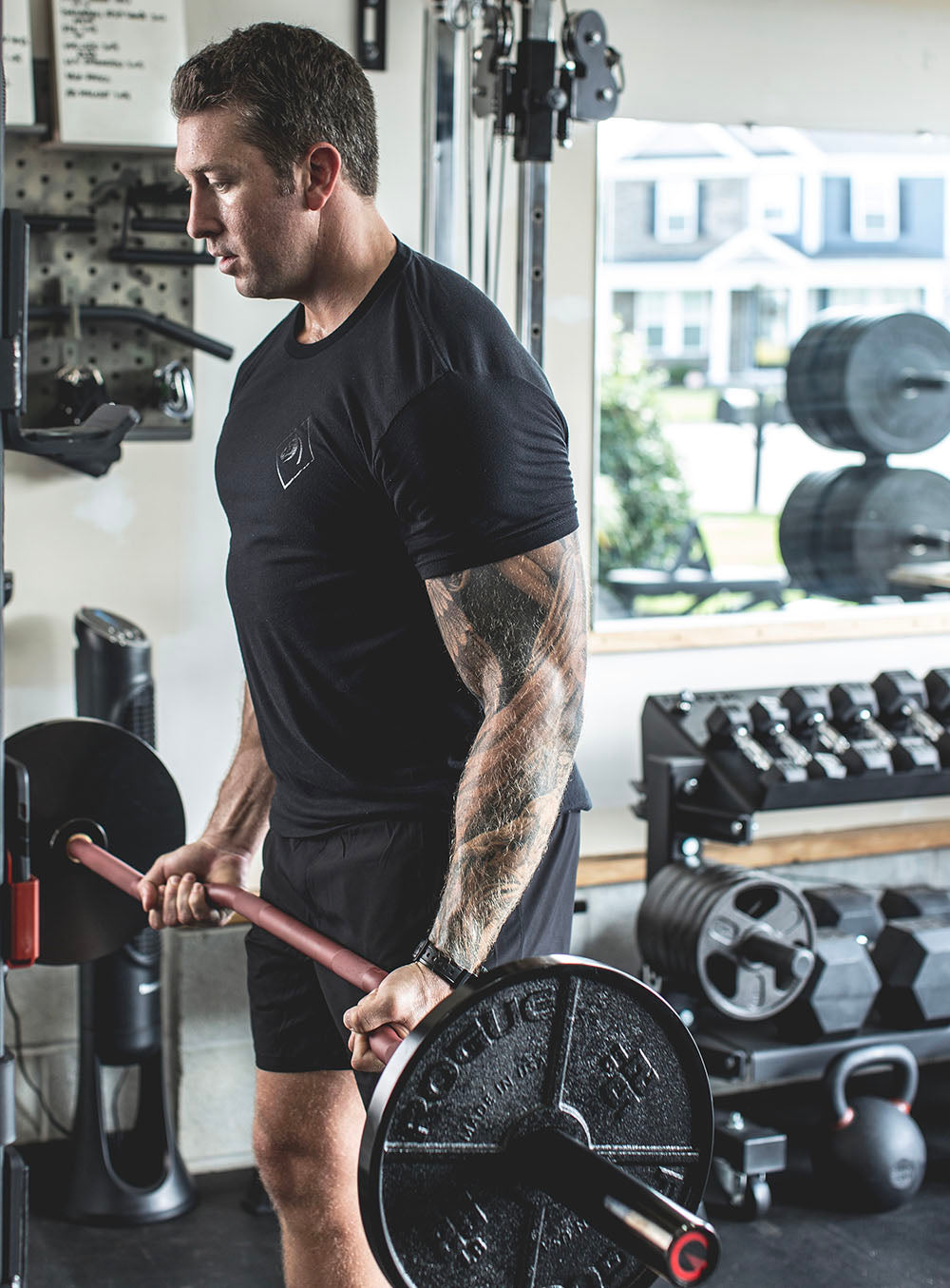 The Edge Bar is a mix between a shortened cambered bar and an EZ Bar. Perfect for enhanced bicep workouts, chest workouts, and more. This image presents the Edge Rackable Cambered Bar being used for a bicep workout.