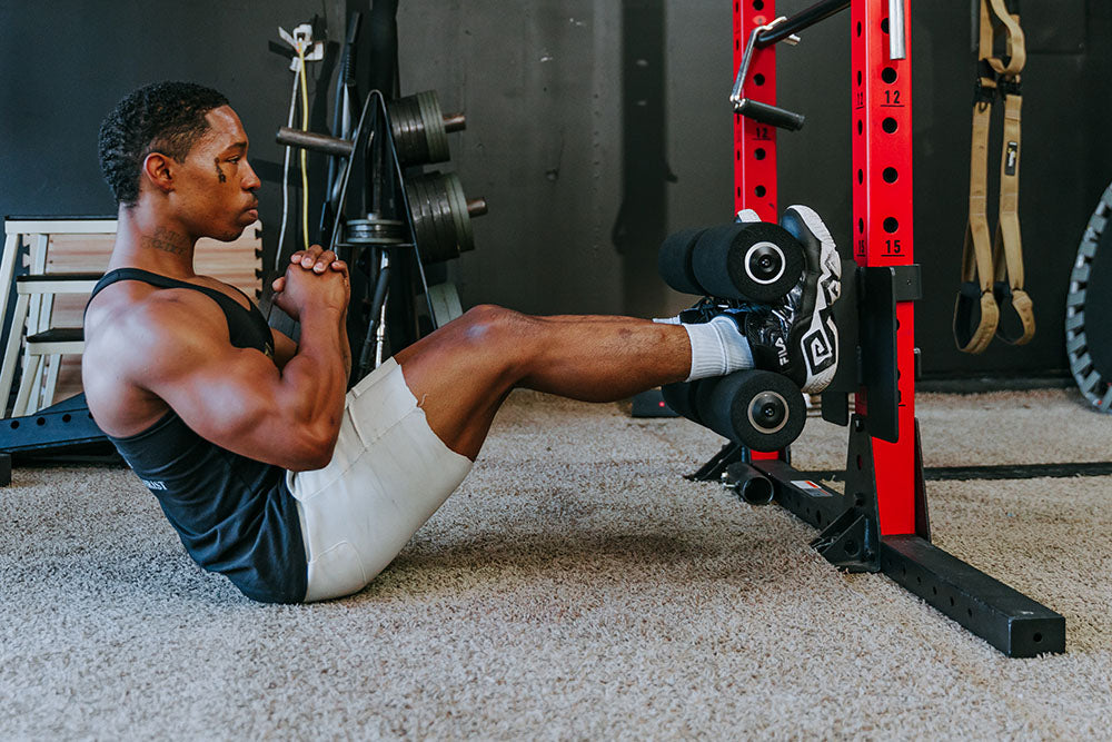 This Rack Mounted Glute Ham Developer is less bulky and lower priced than conventional GHDs. Perfect for glute workouts, ab workouts, and hamstring workouts. This image presents the Rack Mounted Glute Ham Developer being used by a man doing an ab workout.