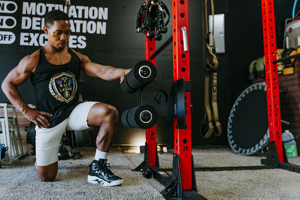 This Rack Mounted Glute Ham Developer is less bulky and lower priced than conventional GHDs. Perfect for glute workouts, ab workouts, and hamstring workouts. This image presents the Rack Mounted Glute Ham Developer on a power rack in a home gym.