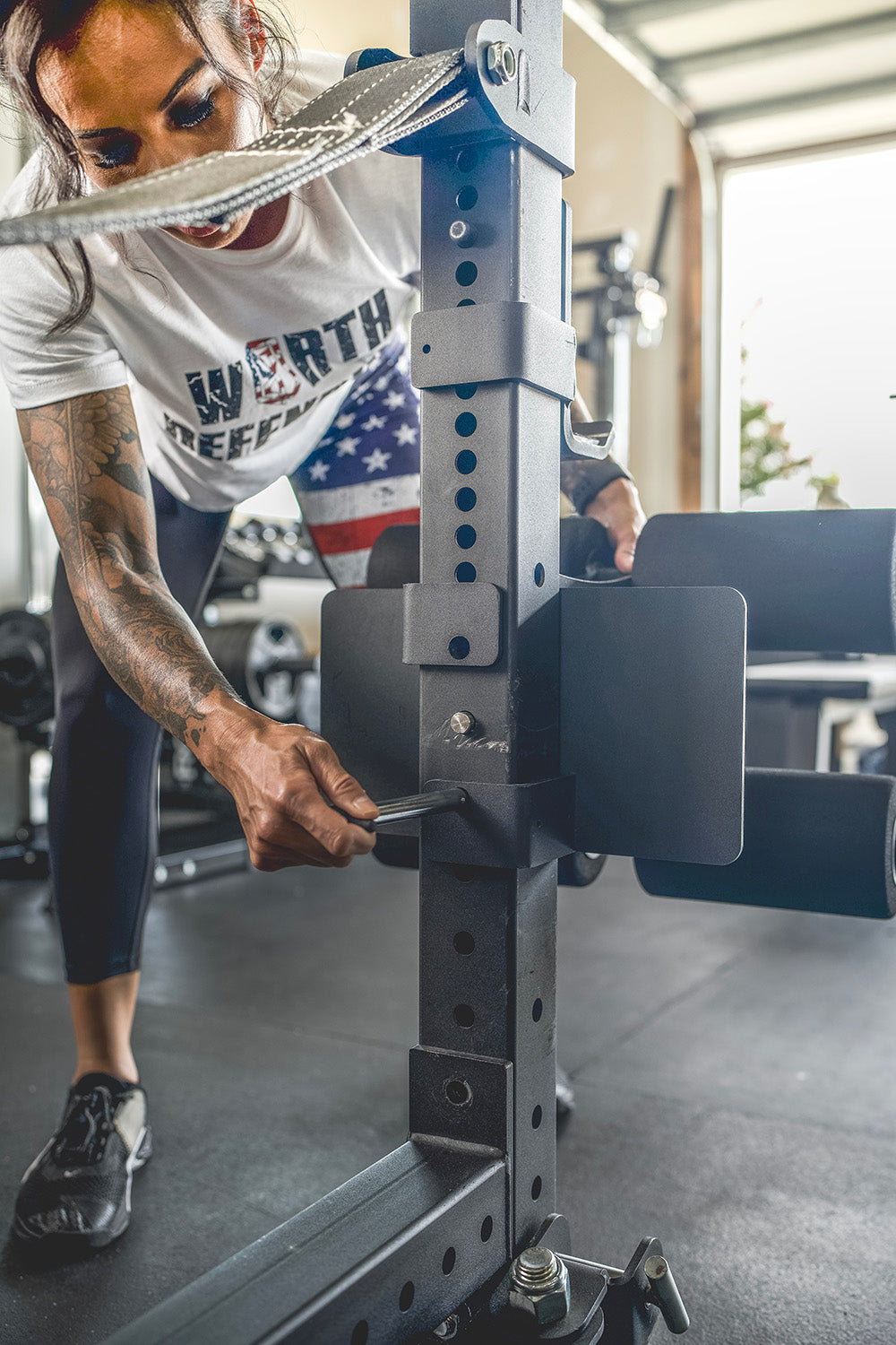 This Rack Mounted Glute Ham Developer is less bulky and lower priced than conventional GHDs. Perfect for glute workouts, ab workouts, and hamstring workouts. This image presents the Rack Mounted Glute Ham Developer being attached on a workout rack in a home gym.