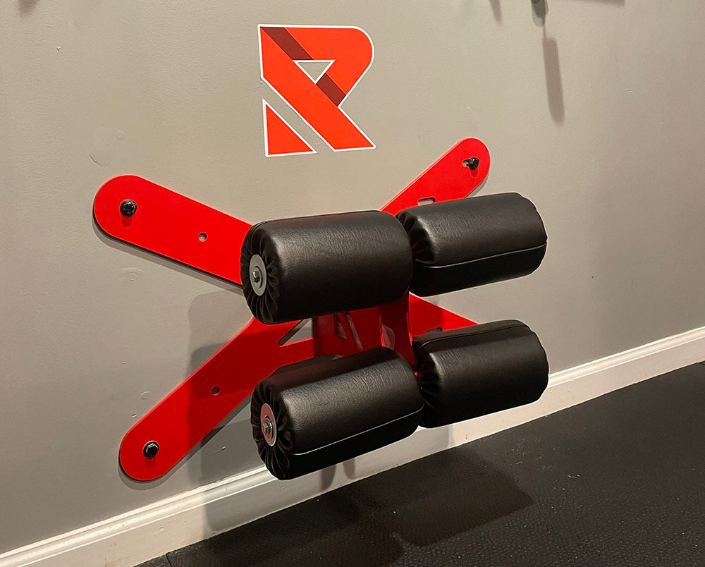 This Wall Mounted Glute Ham Developer is less bulky and lower priced than conventional GHDs. Perfect for glute workouts, ab workouts, and hamstring workouts. This image presents the Wall Mounted Glute Ham Developer (GHD) mounted to the wall in a home gym.